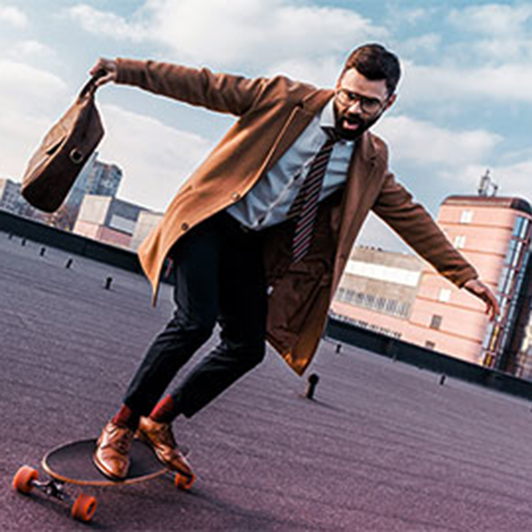 Mann im Anzug fährt Skateboard