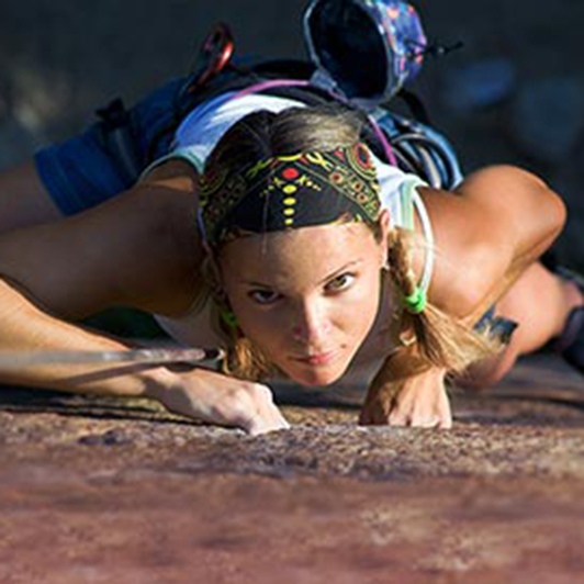 Frau klettert Wand hoch